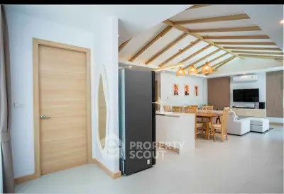 Modern open-layout living room with stylish kitchen and wooden accents