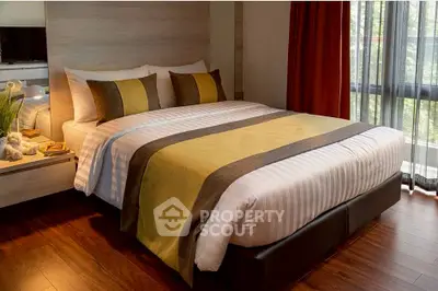 Cozy bedroom with modern decor and large window for natural light