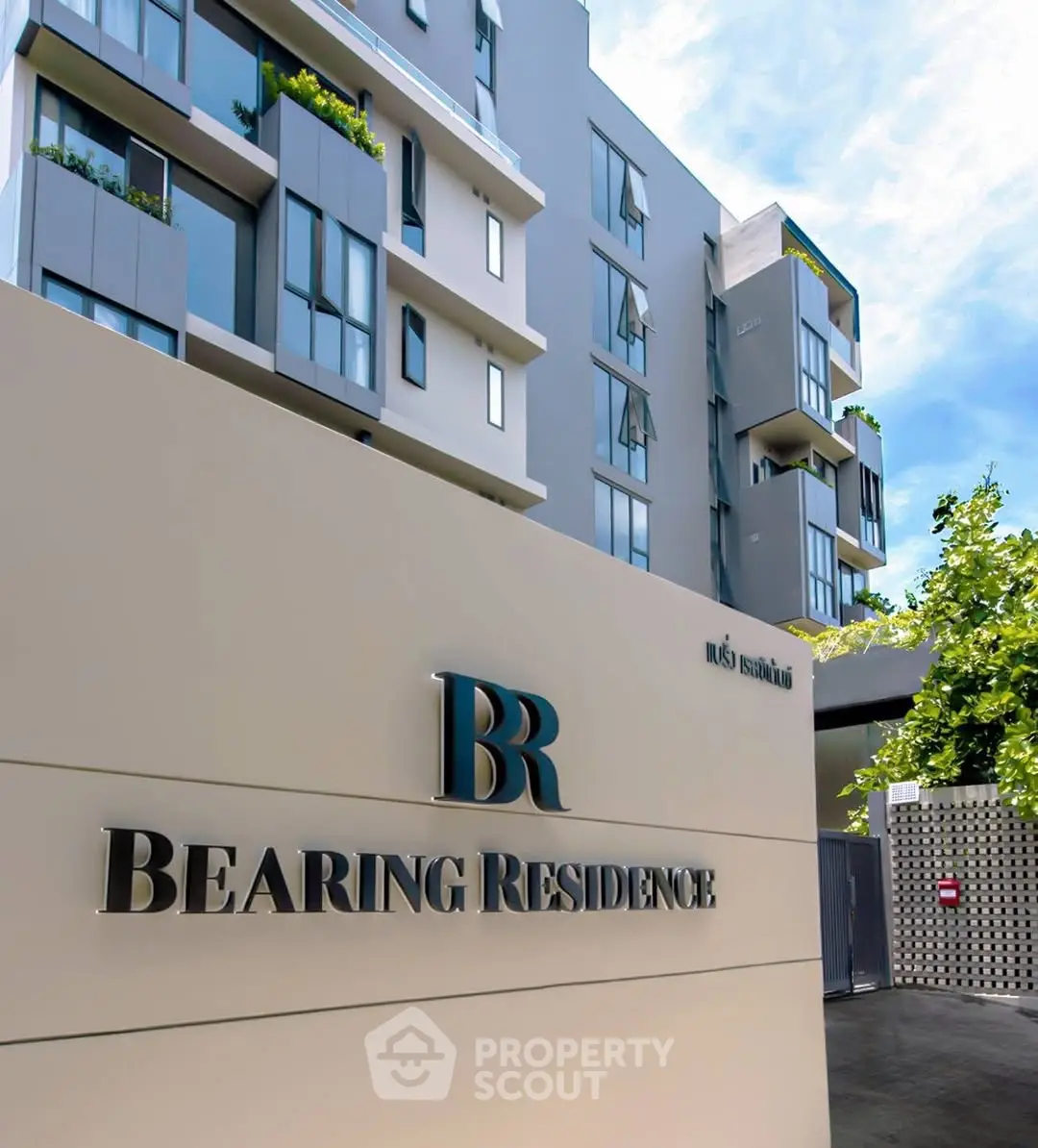 Modern apartment building exterior with sleek design and lush greenery.