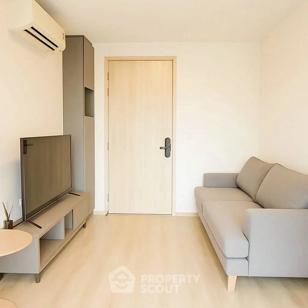 Modern living room with sleek furniture and minimalist design, featuring a cozy sofa and flat-screen TV.