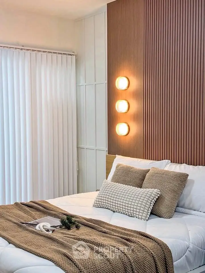 Cozy modern bedroom with stylish wooden accent wall and soft lighting.