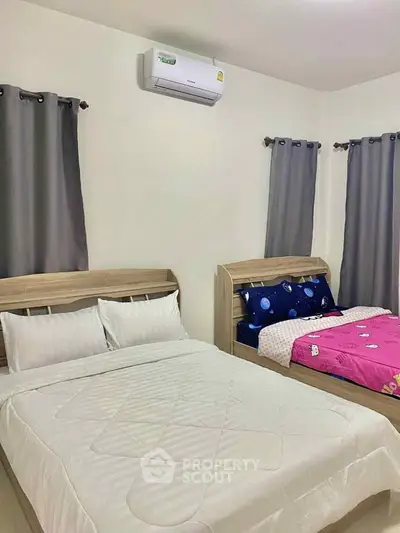 Cozy bedroom with two beds and air conditioning, ideal for comfort and relaxation.