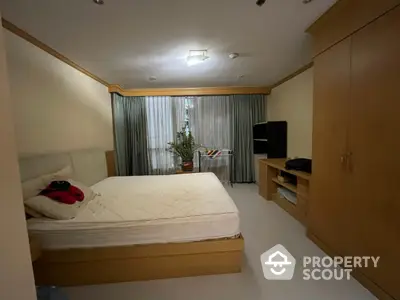 Spacious bedroom with large bed and built-in wardrobe in cozy apartment