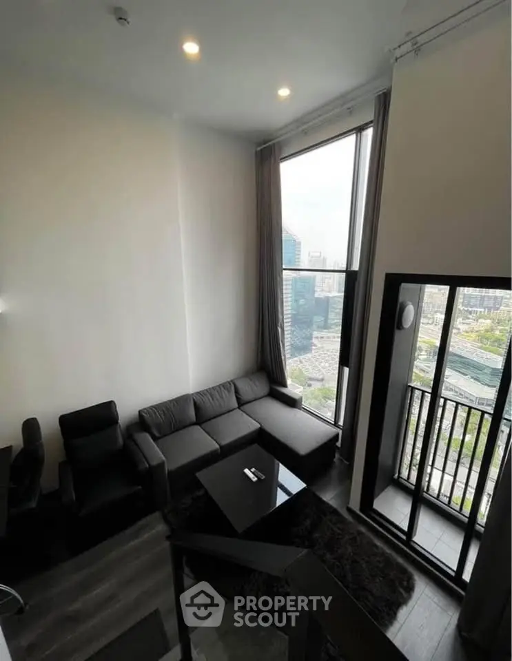 Modern high-rise living room with stunning city view and balcony access.