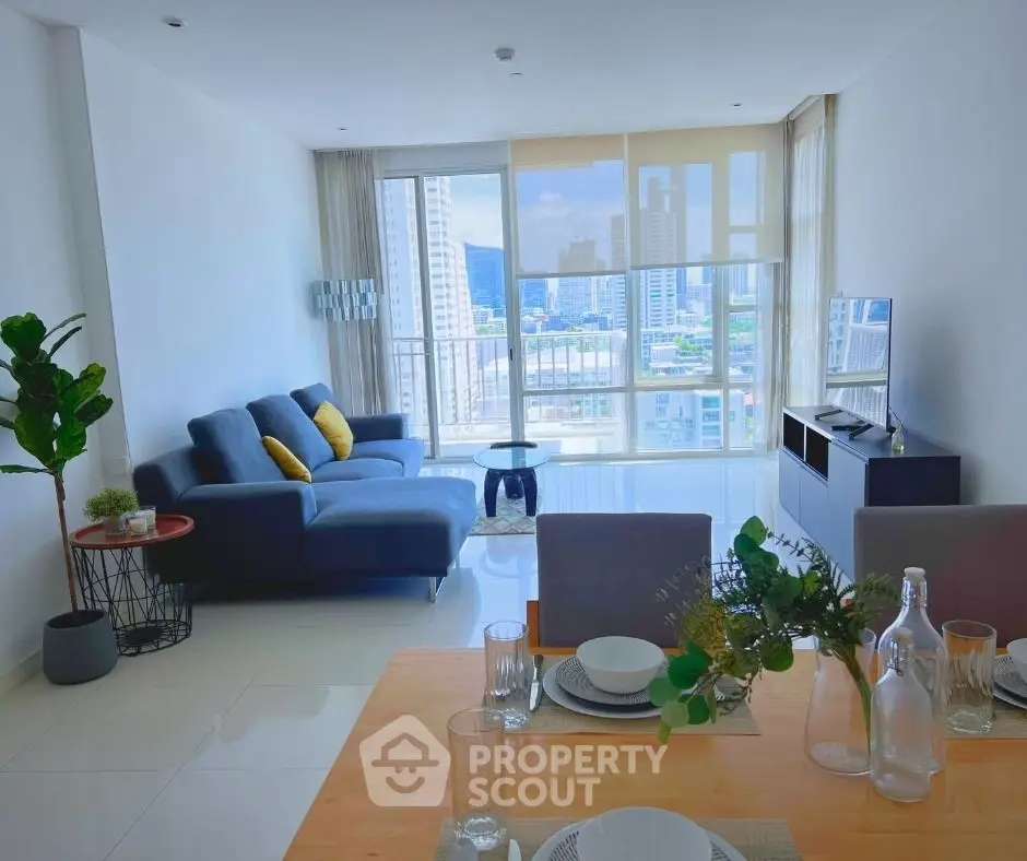 Spacious modern living room with city view, stylish furniture, and elegant dining area in a high-rise apartment.
