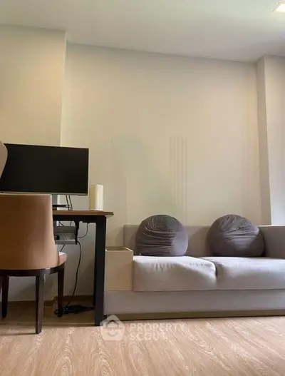 Modern living room with cozy sofa and workspace setup, ideal for urban living.