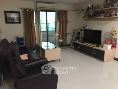Spacious living room with modern furniture and large window for natural light.
