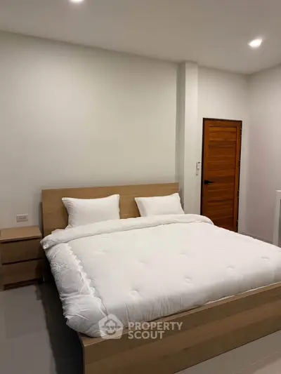 Modern bedroom with minimalist design and cozy bedding in a stylish apartment.