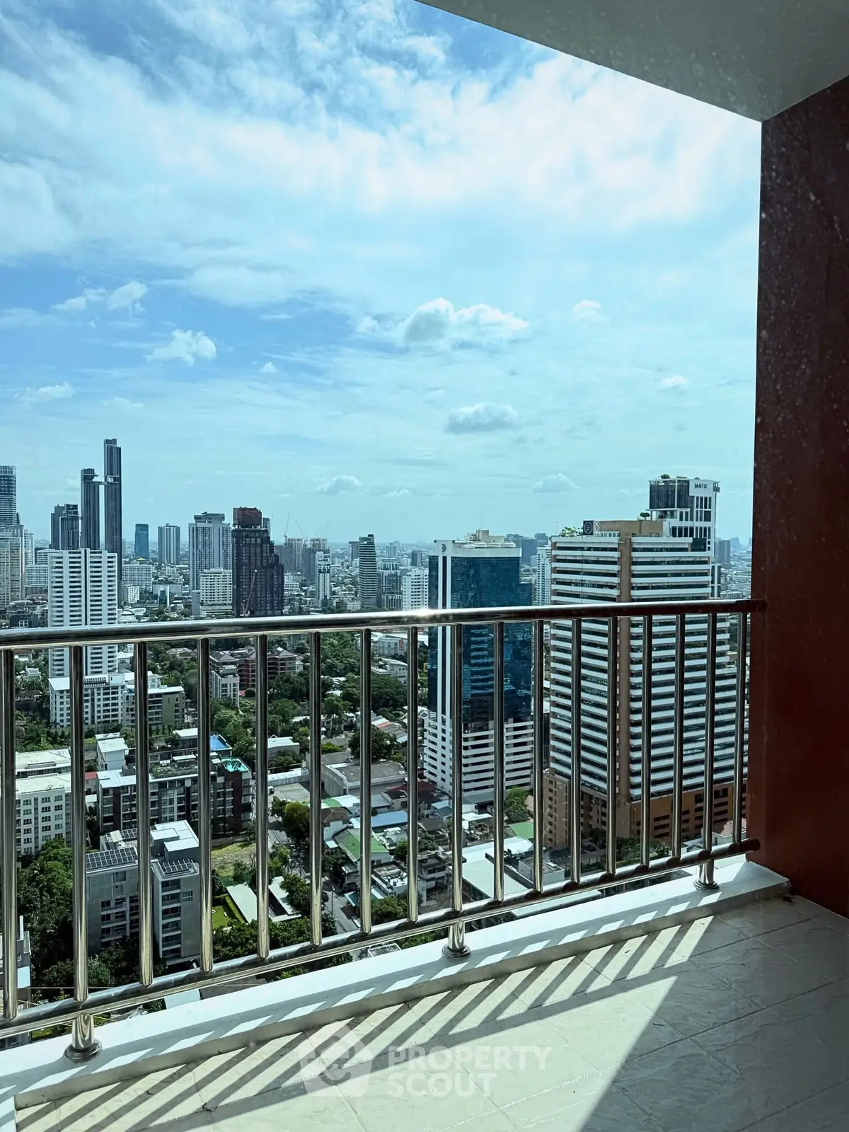 Stunning cityscape view from a high-rise balcony with modern railing.