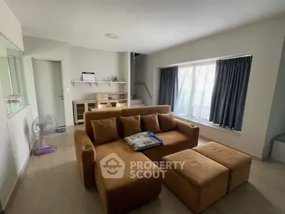 Spacious living room with modern furniture and large window for natural light.