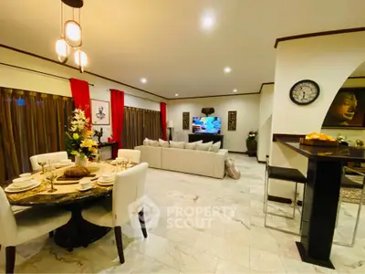 Spacious open living and dining area with elegant decor and modern lighting.