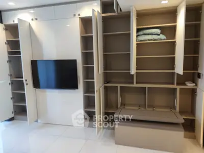 Modern living room with sleek built-in storage and mounted TV, showcasing minimalist design.