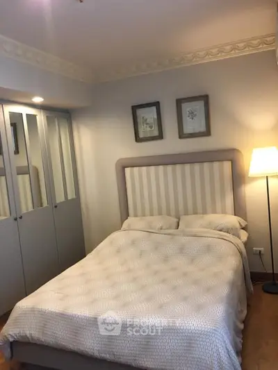 Cozy bedroom with elegant decor and ample closet space, perfect for relaxation and comfort.