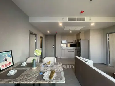 Modern open-plan living room and kitchen with stylish decor and dining area in a contemporary apartment.