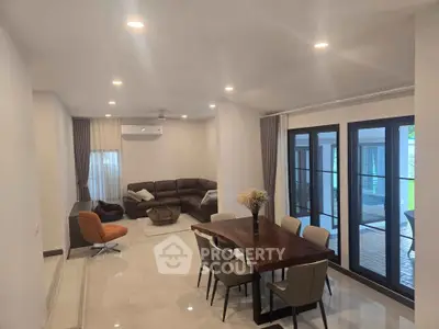 Spacious living and dining area with modern furniture and large windows