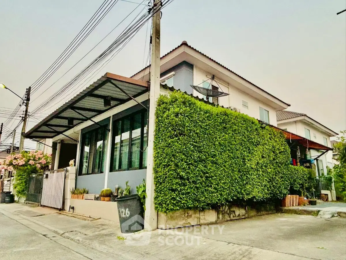 Charming corner house with lush greenery and modern design in a quiet neighborhood.