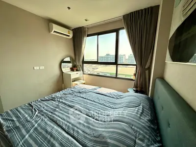 Cozy bedroom with large window and city view, featuring modern decor and air conditioning.