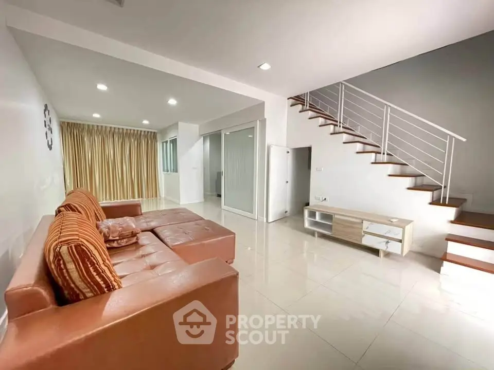 Spacious modern living room with sleek staircase and cozy seating area