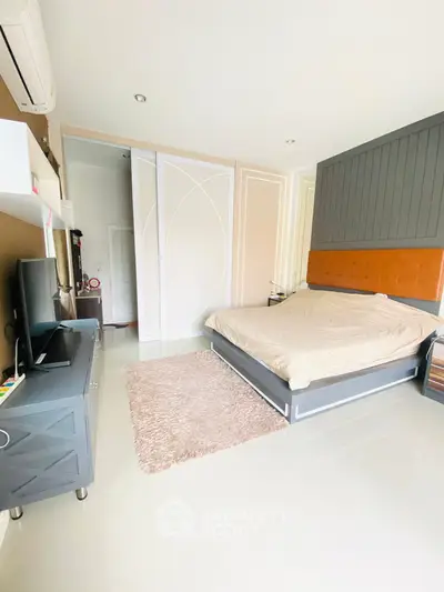 Spacious modern bedroom with stylish decor and ample natural light