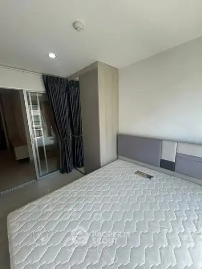 Modern bedroom with large window and stylish curtains in a contemporary apartment.