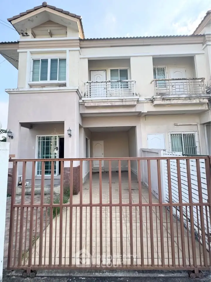 Charming two-story house with gated driveway and balcony, perfect for family living.