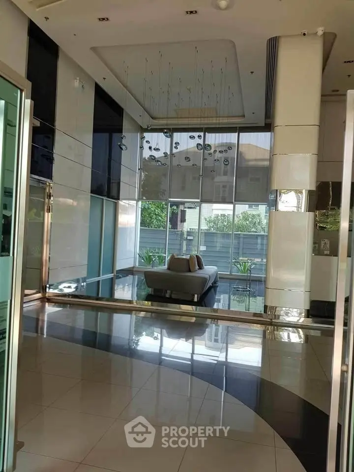 Luxurious modern building entrance with sleek design and elegant lighting.