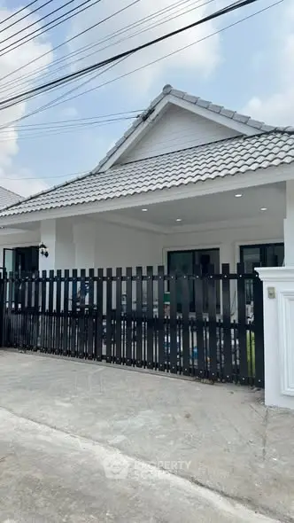 Charming single-story house with modern fence and tiled roof, perfect for family living.