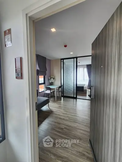 Modern apartment interior with stylish living room and bedroom, featuring wood flooring and elegant decor.
