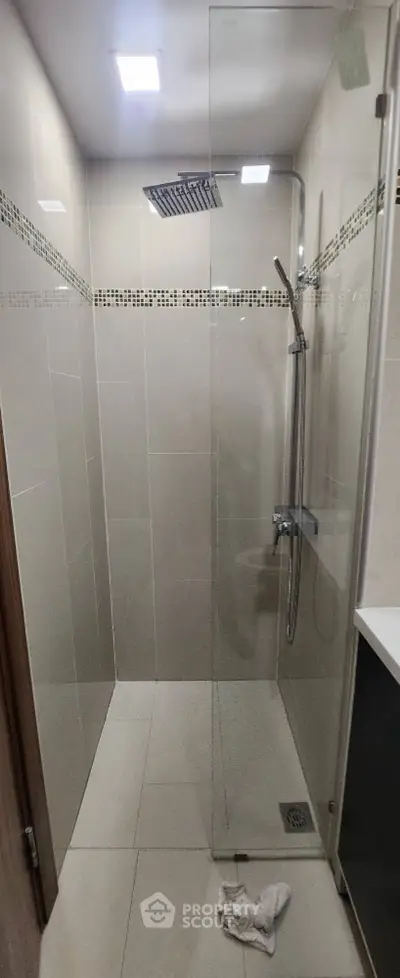 Modern bathroom with glass shower enclosure and rainfall showerhead