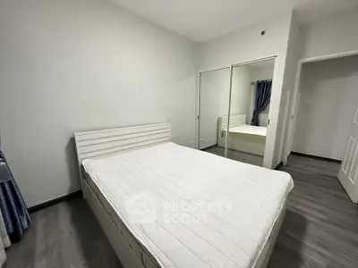 Spacious bedroom with mirrored closet and modern decor