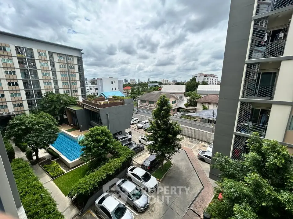 Modern residential complex with pool and parking view from balcony.