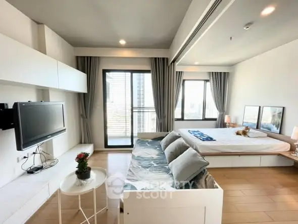 Modern studio apartment with sleek design and large windows offering city views.