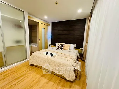 Modern bedroom with cozy decor and wooden flooring in a stylish apartment.