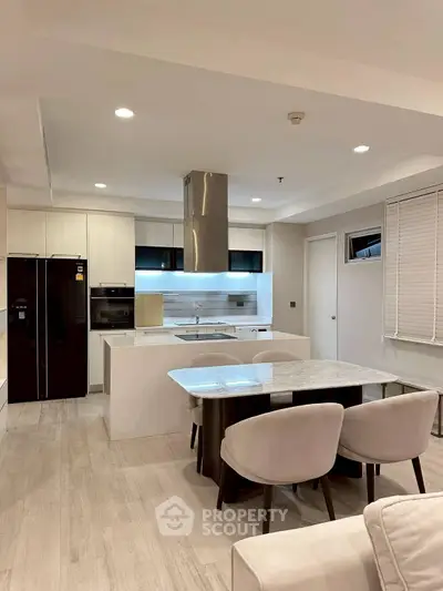 Modern kitchen with sleek design, featuring an open layout and stylish dining area.