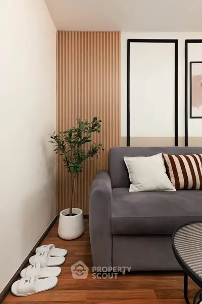 Stylish modern living room with cozy gray sofa, wooden accents, and decorative plant for a warm ambiance.