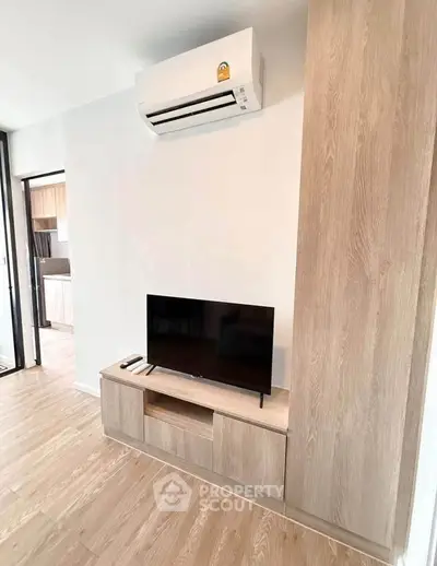 Modern living room with sleek wooden TV stand and air conditioning unit, showcasing minimalist design.