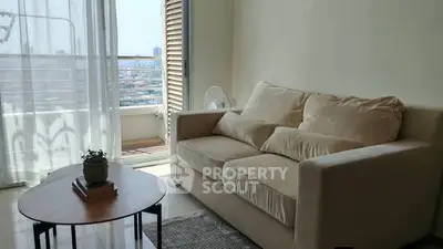 Cozy living room with beige sofa and city view balcony