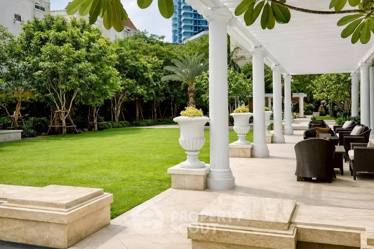Luxurious garden with elegant seating area and lush greenery in upscale property.