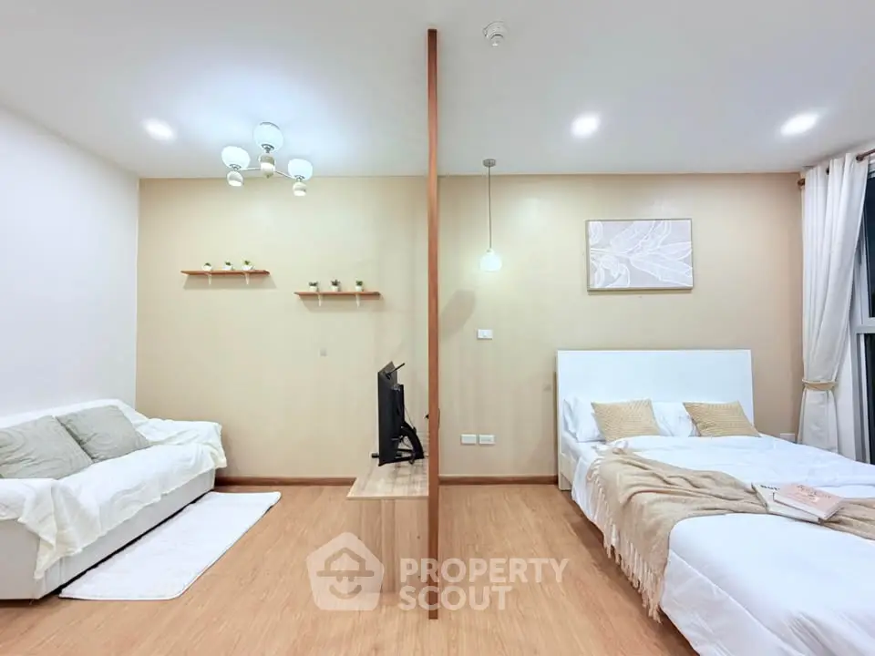 Modern studio apartment with cozy living area and comfortable bed, featuring stylish decor and warm lighting.