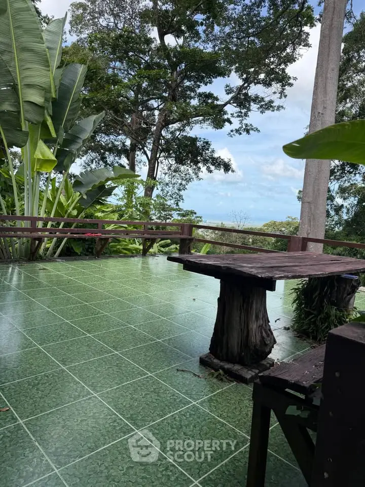 Stunning outdoor terrace with lush greenery and ocean view, perfect for relaxation and entertaining.