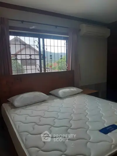 Cozy bedroom with large window and scenic view, featuring a comfortable bed and air conditioning.