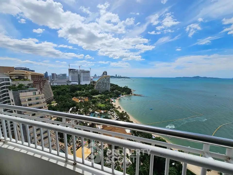 Stunning ocean view from high-rise balcony overlooking city skyline and beach.