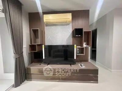 Modern living room with sleek TV unit and air conditioning, featuring stylish shelving and neutral decor.
