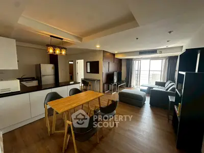 Spacious open-plan living room with modern kitchen and large windows.