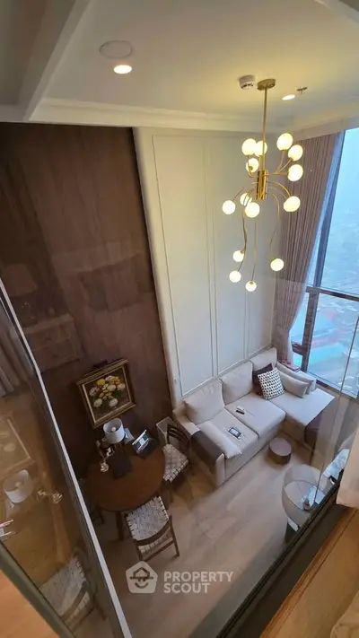 Luxurious high-ceiling living room with modern chandelier and panoramic city view.
