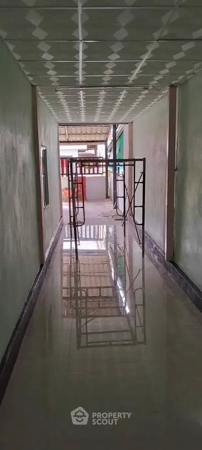 Spacious hallway with glossy tiled floor leading to an outdoor area, ideal for commercial use.