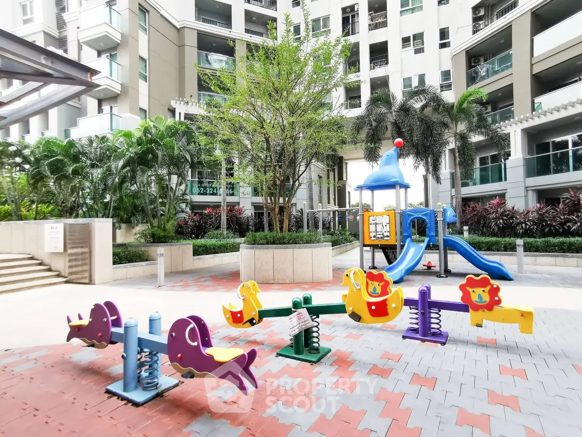 Modern residential building with vibrant playground and lush greenery