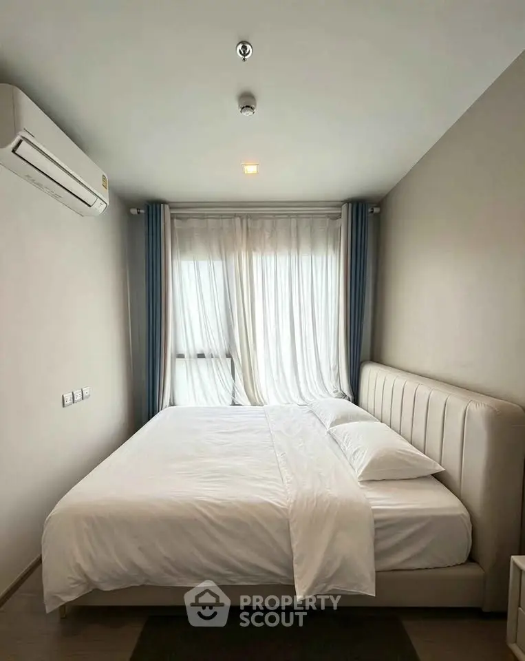 Cozy bedroom with modern decor and natural light, featuring a comfortable bed and elegant curtains.