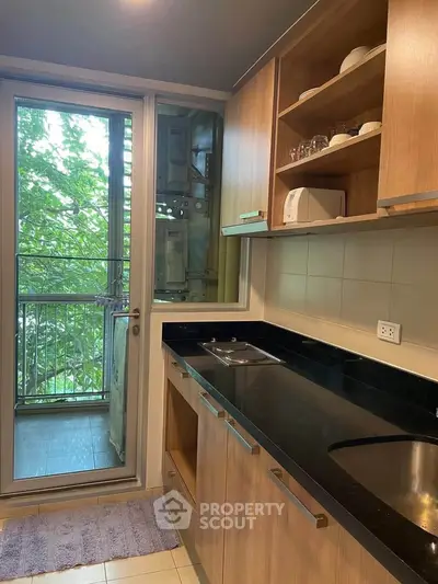 Modern kitchen with sleek wooden cabinets and balcony view