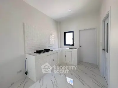 Modern kitchen with sleek white cabinetry and gas stove in a bright, minimalist design.
